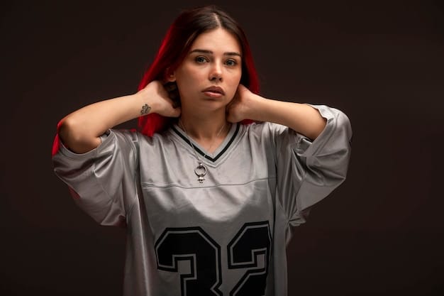 A close-up studio portrait of a young Indonesian female esports athlete, wearing a team jersey, confidently looking at the camera, with a gaming headset around her neck.